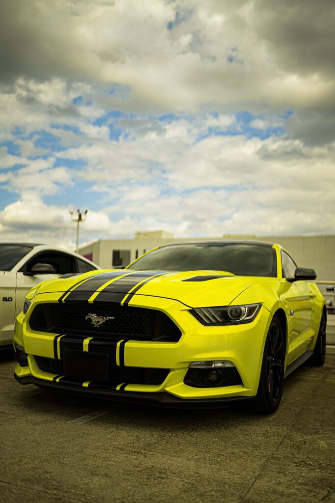 Neon-lit Mustang parked in urban parking lot, retouched with Photoshop gradient maps, dodge & burn, and tonal adjustments for cyberpunk realism