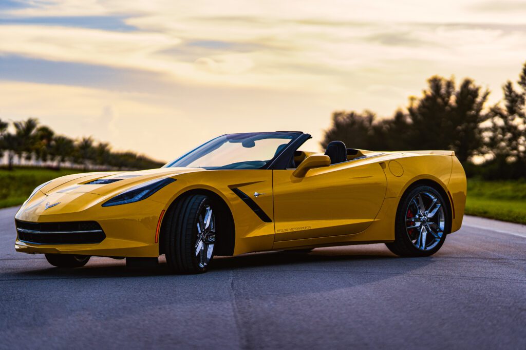 Yellow Corvette parked on country road at evening, retouched with Photoshop dodge & burn, gradient maps, and tonal adjustments for cinematic warmth and clarity.