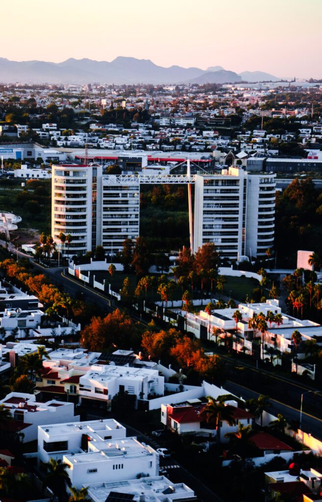 Townhouse at dusk color-graded in la noir Da Vinci signature tone, showing facade, arched windows, and planted approach.